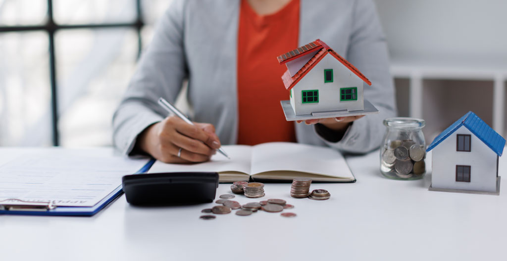 Couple de seniors assis côte à côte regardant ensemble une tablette posée sur leurs genoux dans un salon confortable