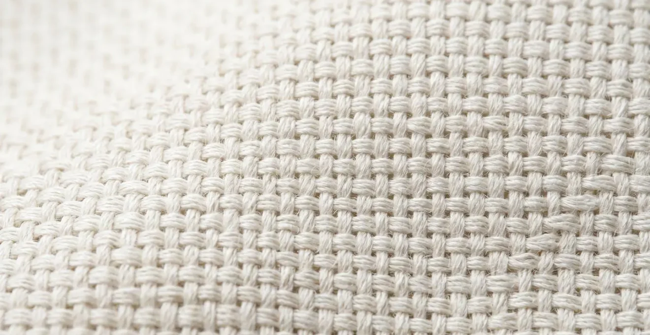 Gros plan macro sur la texture d'un tissu en percale montrant l'armure toile serrée avec des fils entrecroisés bien visibles